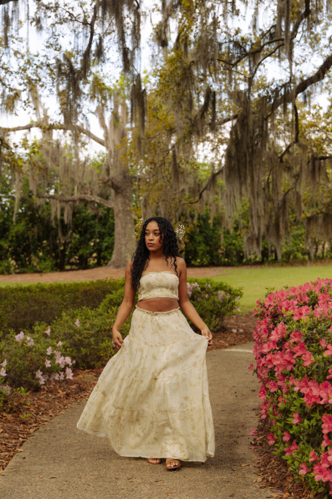 Holistic nurse walking through blooming azaleas during a branding session at Sholom Park in Ocala Florida