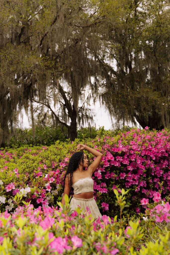 Holistic wellness professional posing among bright pink azaleas at Sholom Park in Ocala Florida