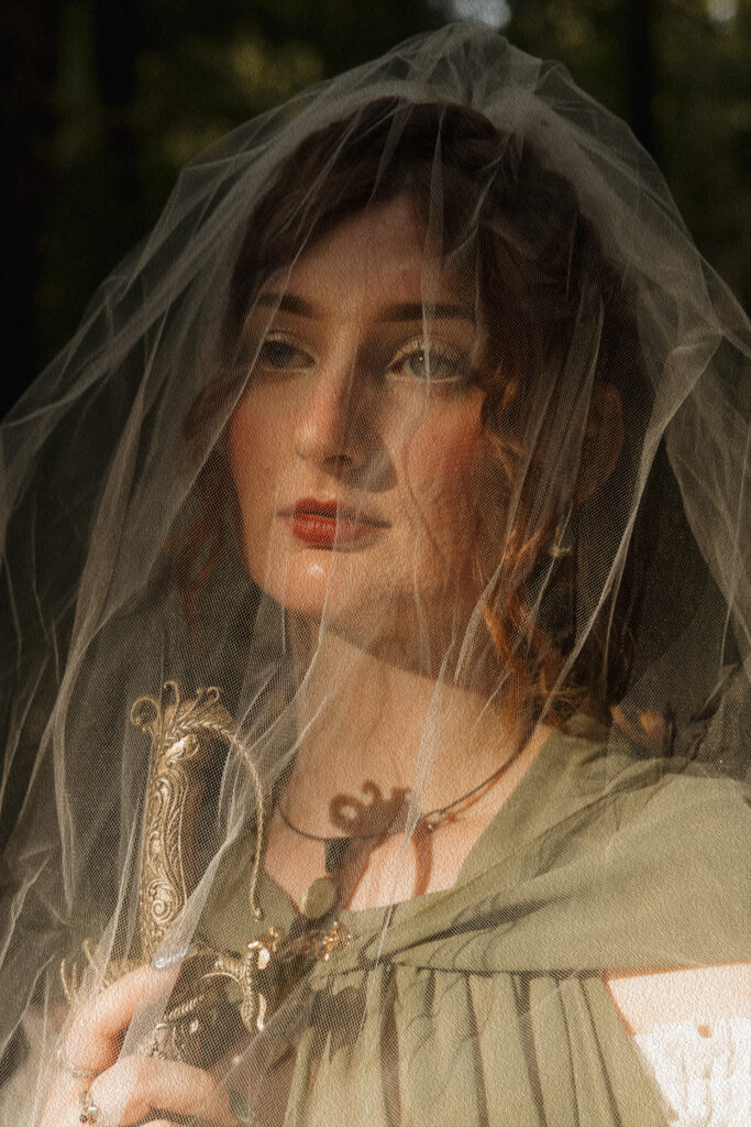 Woman holding a sword close to her face during a fantasy portrait session at Scott Springs Park