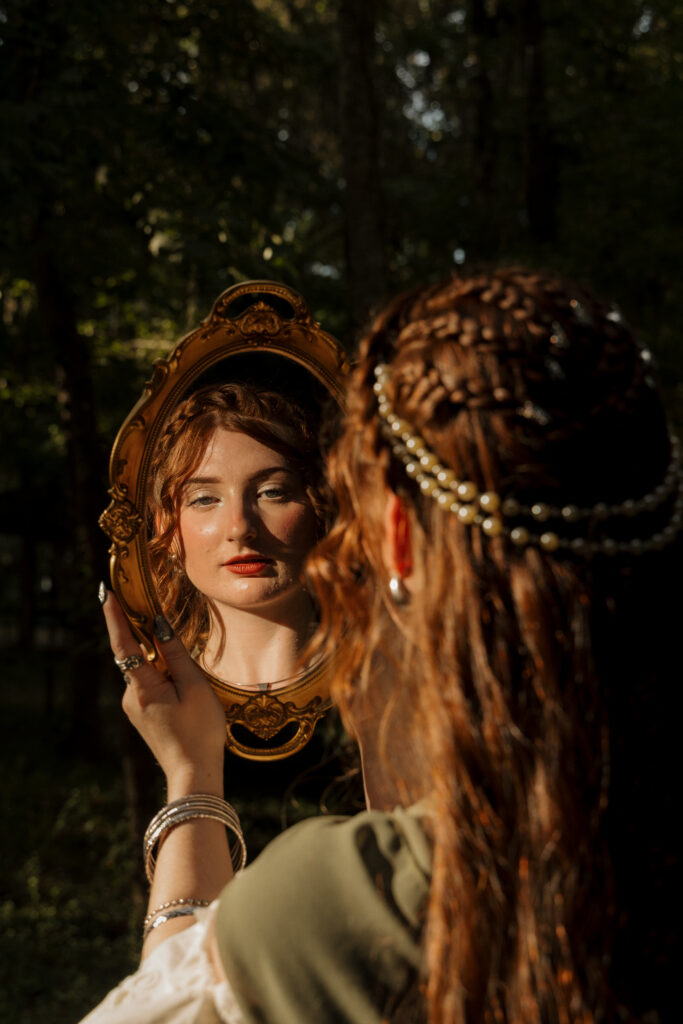 Woman looking into an ornate mirror during a medieval fantasy portrait session at Scott Springs Park