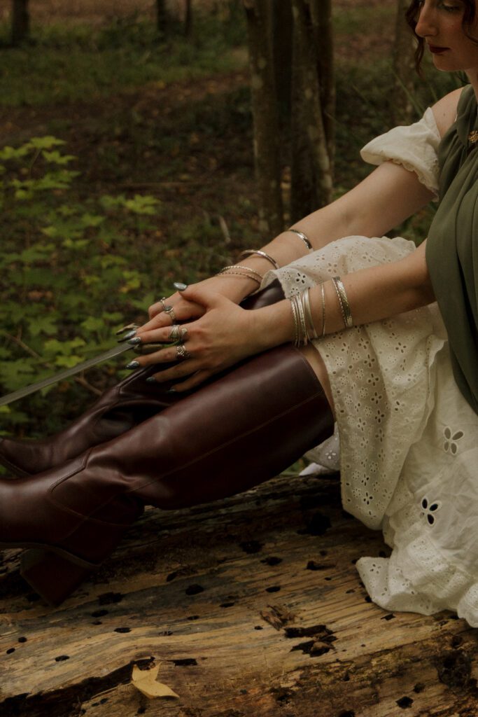 Woman seated in a wooded setting wearing a medieval inspired outfit during a portrait session at Scott Springs Park