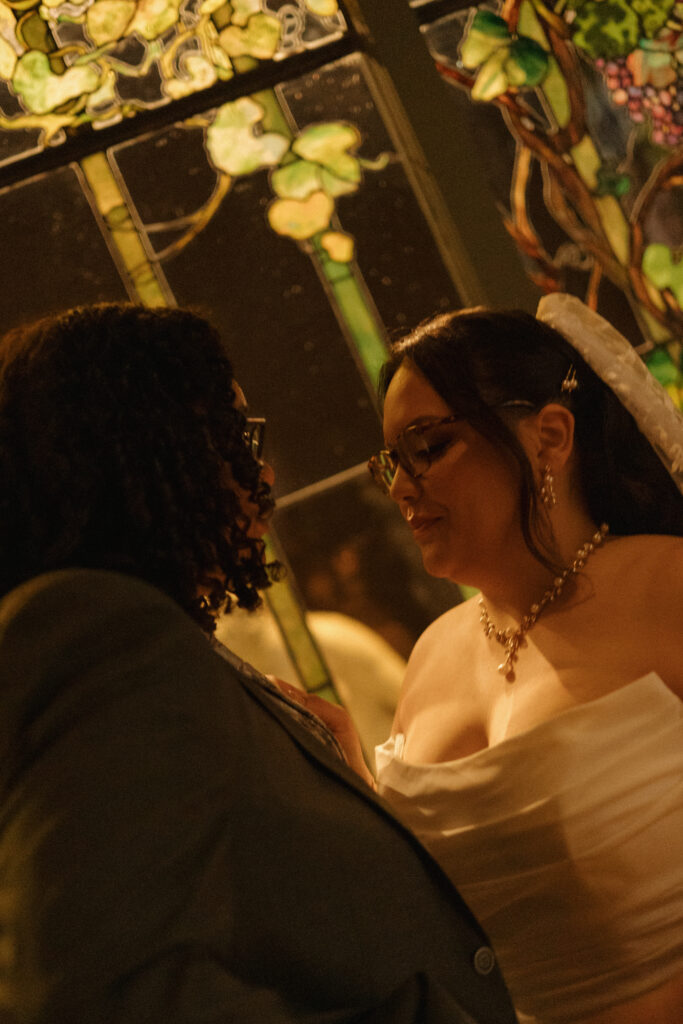 Newlyweds sharing a quiet moment in front of stained glass at the Morse Museum