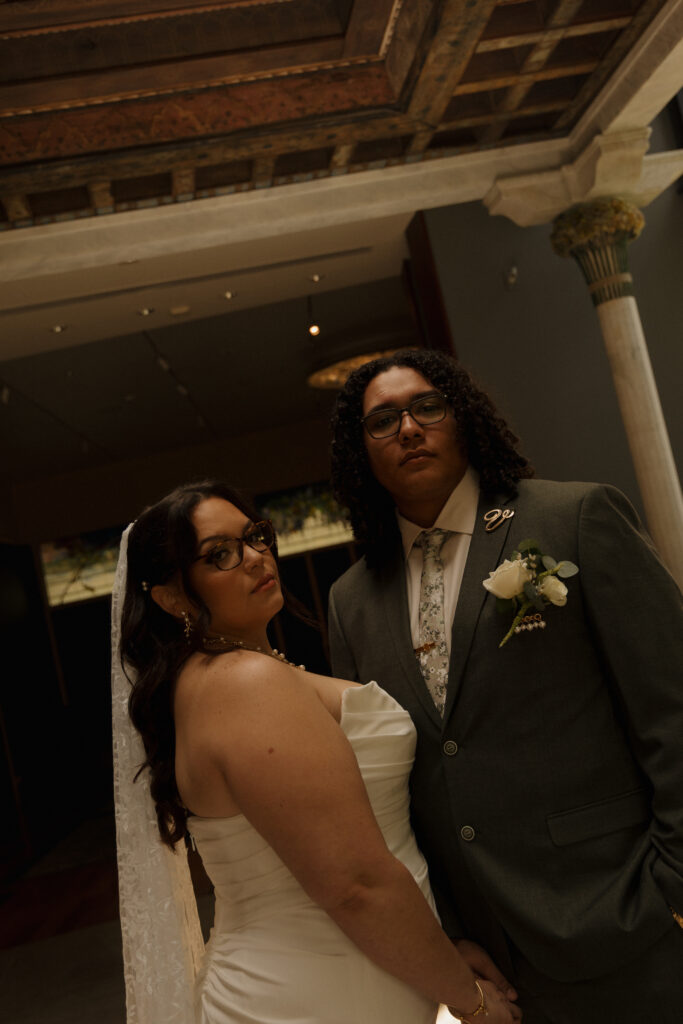 Bride and groom posing together inside the Charles Hosmer Morse Museum of American Art