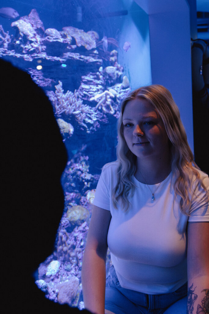 The couple smiles together during their aquarium date.