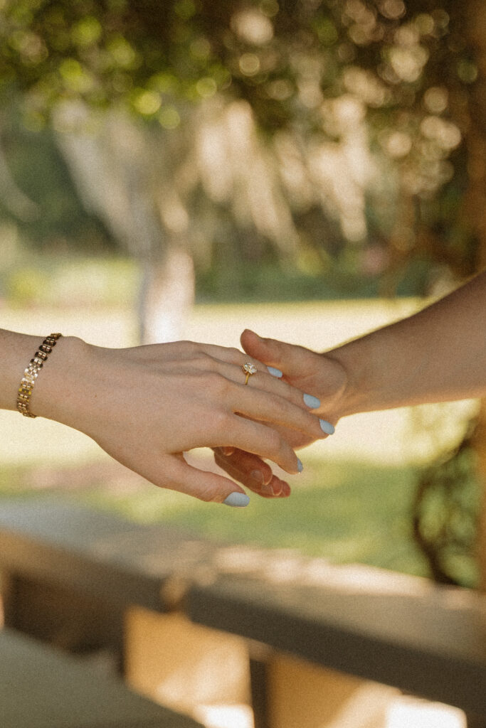 Close up of an engagement ring as the couple holds hands during their Ocala engagement session