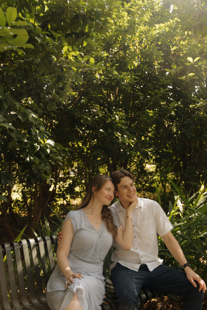 Couple sitting together on a garden bench during their Sholom Park engagement photos